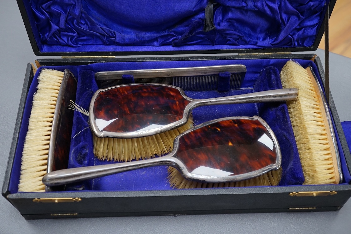 A George V five piece silver and tortoiseshell mounted dressing table set, W G Sothers Ltd, Birmingham, 1926, together with an earlier similar comb, in associated case.